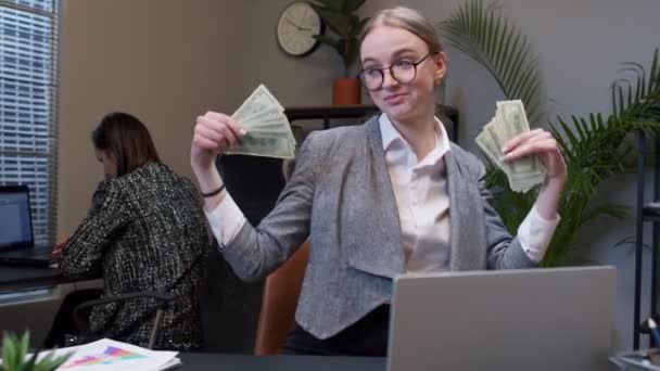 Mujer de negocios gerente de la empresa celebrando el éxito, bailando con pila de dinero en efectivo en efectivo en la oficina — Vídeo de stock