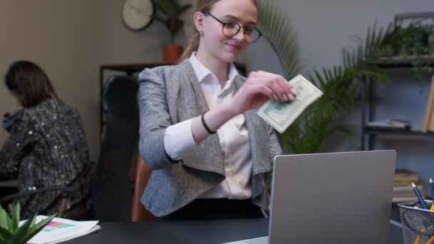 Donna d'affari che riceve denaro reddito in contanti dal computer portatile in carica dopo l'affare finanziario di successo — Video Stock