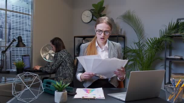 Memnun olmayan iş kadını muhasebeci mali ofis belgelerini inceledikten sonra belgeleri fırlatıyor. — Stok video