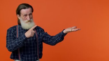 Olgun büyükbaba parmakla işaret ediyor ve boş yeri işaret ediyor. Ticari metinler için reklam alanı.
