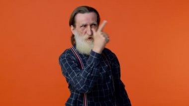 Yaşlı, sakallı bir adam, el tabancasıyla işaret ediyor, tabancayla öldürüyor.