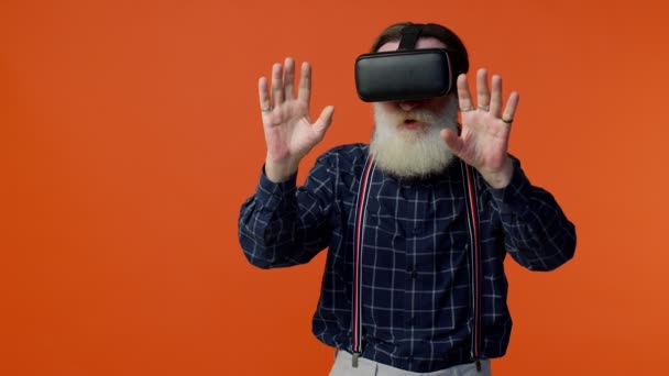 ヘッドセットヘルメットアプリを使用してシミュレーション仮想現実VRゲームをプレイする高齢者スタイリッシュな白髪の男 — ストック動画