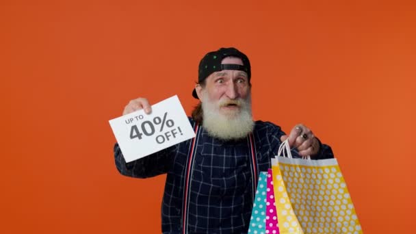 Älterer bärtiger Mann zeigt Einkaufstüten und bis zu 40 Prozent Rabatt auf Aufschriften, Black Friday — Stockvideo