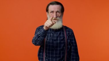 Olgun yaşlı adam kamerayı işaret ediyor, şüpheli bir şekilde seçiyor ve bakıyor, suçlu olduğunu fark ediyor.