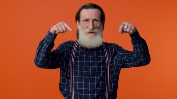 Senior oude man met baard die naar beneden wijst, zegt te abonneren, te gebaren ok en dergelijke, informatie hieronder — Stockvideo