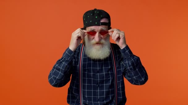 Retrato de idoso sedutor velho barbudo homem de cabelos grisalhos vestindo óculos de sol, sorriso encantador — Vídeo de Stock