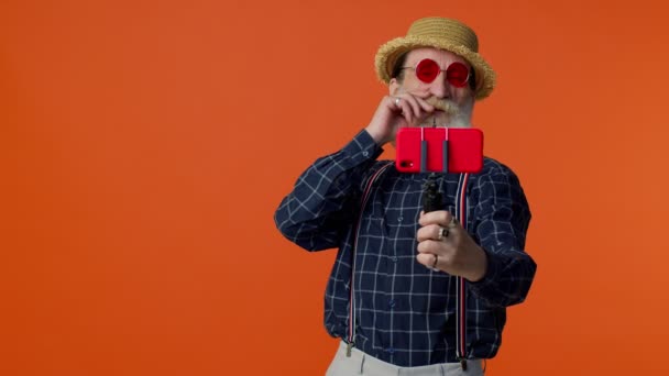 Ανώτερος παππούς ταξιδιώτη blogger σε γυαλιά ηλίου, λήψη selfie στο smartphone, βιντεοκλήση σε απευθείας σύνδεση — Αρχείο Βίντεο