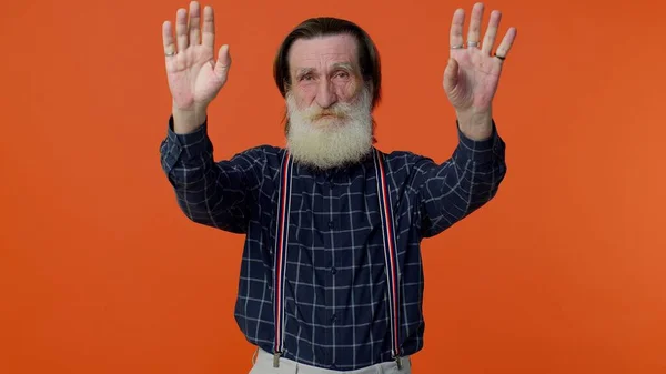 Happy friendly elderly man waves hand palm in hello gesture welcomes someone positive emotions — Stock Photo, Image