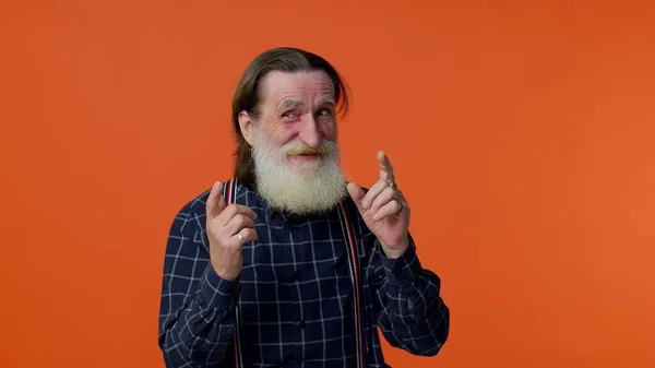 Egy kicsit őrült, idősebb szakállas férfi, aki a nyelvét mutogatja, bolondozik, buta arcokat csinál, megőrül. — Stock Fotó