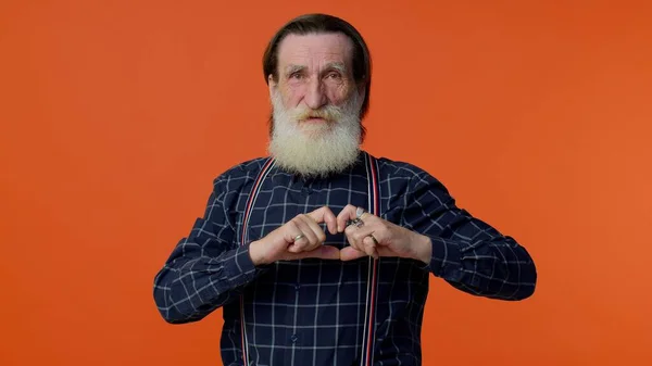Smiling senior man makes heart gesture demonstrasikan tanda cinta mengungkapkan perasaan dan simpati yang baik — Stok Foto