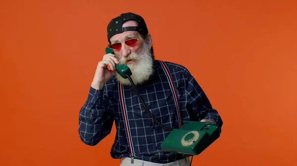 Senior bearded gray-haired man talking on wired vintage telephone of 80s, says hey you call me back — Stock Photo, Image