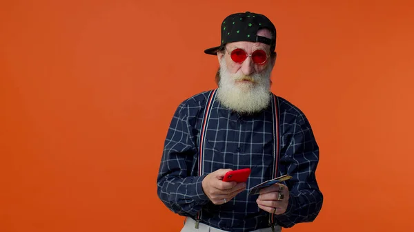 Senior velho homem barbudo elegante usando cartão de crédito bancário e compras de smartphones compras on-line — Fotografia de Stock