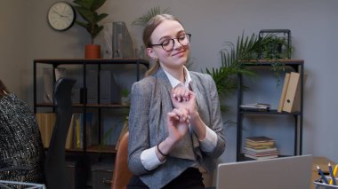 İş kadını yöneticisi masa başında çalışıyor, dans ediyor, zaferi kutluyor iyi iş başarısını kutluyor.