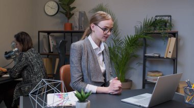 İş kadını dizüstü bilgisayar kullanıyor, internet üzerinden toplantı yapıyor web kamerasından konuşuyor.