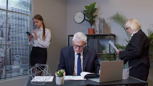 선임 프리랜서는 사무실에 있는 노트북 컴퓨터로 타자를 하면서 작업하는 일에 집중하였다 — 스톡 사진