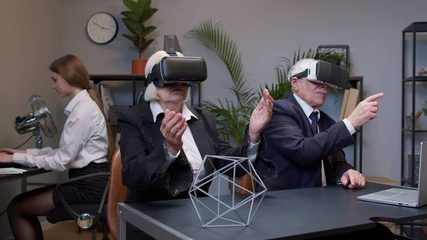 Colegas de negócios sênior usando realidade virtual capacete de fone de ouvido aplicativo 3D fazendo pesquisa assistindo vídeo — Fotografia de Stock