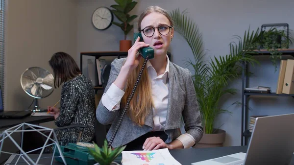 生气的年轻女商人用复古电话交谈，她的声音很恼怒，对工作不满 — 图库照片