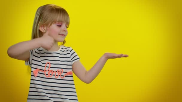 Graciosa niña mostrando pulgares hacia arriba y señalando lugar vacío, área de publicidad para texto comercial — Vídeo de stock
