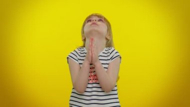 Çocuk kız içtenlikle Tanrı 'ya dua ediyor ve yalvaran bir ifadeyle yukarı bakıyor, özür diliyor, yardım