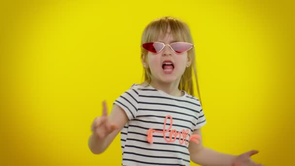 Маленькая девочка-подросток в солнечных очках слушает музыку танцевальной дискотеки, валяет дурака, веселится — стоковое видео