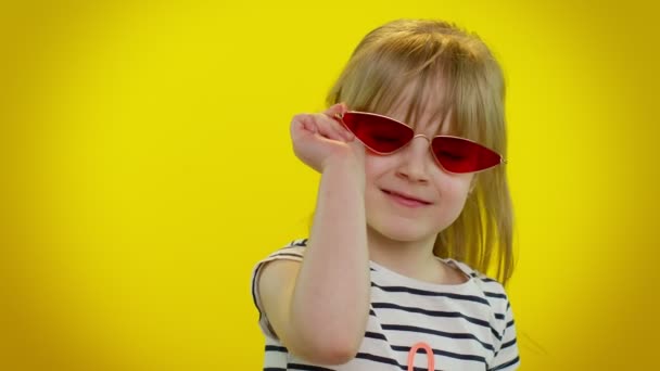 Lekfull glad barn flicka i solglasögon blinkande öga, tittar på kameran med leende, blinkande, flörtande — Stockvideo