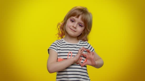 Sourire enfant fille fait geste de coeur démontre signe d'amour exprime de bons sentiments et de sympathie — Video