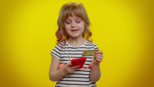 Dziecko dziewczynka używać telefonu komórkowego i plastikowej karty kredytowej, przeglądając powiedzieć wow tak, wielkie zwycięstwo — Wideo stockowe