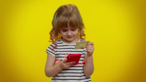 Kleine tiener kind meisje met behulp van credit bank kaart en mobiele telefoon tijdens de aankoop van online winkelen — Stockvideo