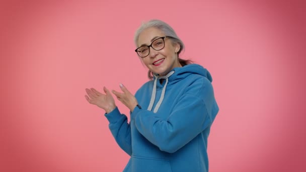Ältere Seniorin zeigt einladende Geste mit den Händen, bittet zum Mitmachen, winkt zum Kommen — Stockvideo