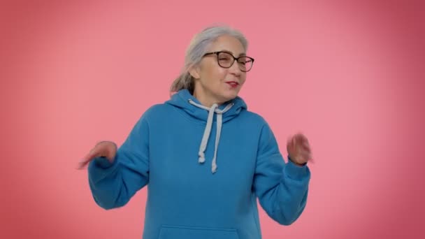 Kypsä vanha mummo nainen tekee leikkisä typerä ilmeet, irvistys, huijaaminen, osoittaa kieli — kuvapankkivideo