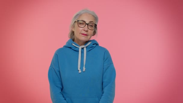 Verspielt glückliche ältere Oma blinzelt mit den Augen, blickt lächelnd in die Kamera und drückt Optimismus aus — Stockvideo
