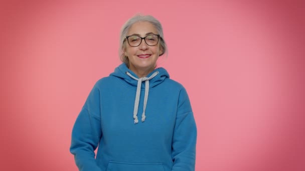 Glad lekfull äldre mormor kvinna blinkande öga, tittar på kameran med leende, uttrycker optimism — Stockvideo