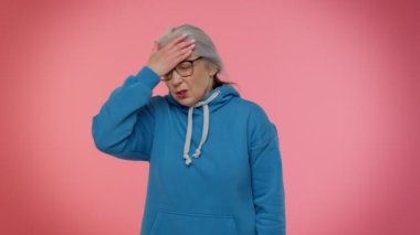 Üzgün yaşlı kadın surat ifadesi yapıyor. Sıkılmış, hayal kırıklığına uğramış, kötü haber.
