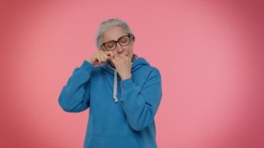 Hayal kırıklığına uğramış yaşlı kadın, haksız şeyler yüzünden gözyaşlarını siliyor ve umutsuzluktan ağlıyor.