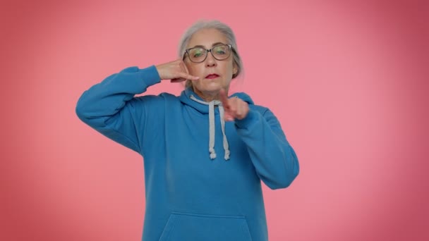 Senior Oma grauhaarige Frau schaut in die Kamera dabei Handygeste wie sagt hey Sie rufen mich zurück — Stockvideo