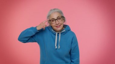 Yaşlı bir kadın kamerayı işaret edip aptalca bir hareket yapıyor ve bir aptalı delice bir plan için suçluyor.