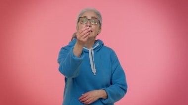 Olgun yaşlı bir kadın israf ediyor ya da etrafa para saçıyor. El hareketi, daha fazla bahşiş, büyük kar.