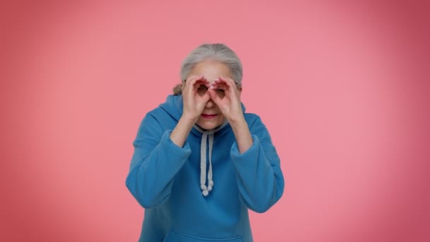 Nosy curious senior granny woman closing eyes with hand, spying through fingers, hiding, peeping — Stock Video