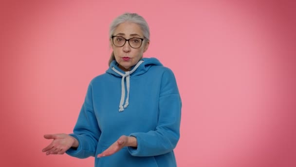 Старша жінка піднімає руки в обуреному вираженні, питаючи чому, які причини невдач, роздратування — стокове відео