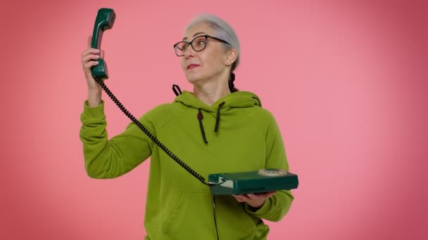 Crazy elderly granny old woman talking on wired vintage telephone of 80s, fooling making silly faces — Stock Video