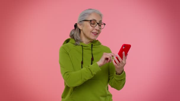 Senior alte Oma mit dem Handy tippt neue Post, SMS-Nachricht, Surfen, soziale Netzwerke — Stockvideo