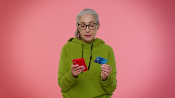 Senior oude stijlvolle oma vrouw met behulp van credit bank kaart en smartphone aankopen online winkelen — Stockvideo