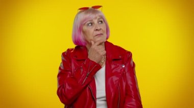 Düşünceli, zeki, yaşlı, yaşlı büyükanne kadın çenesini ovuşturuyor. Çözüm üzerinde kafa yoruyor, şüpheli bir soru.