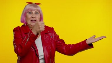 Olgun büyükanne işaret ediyor ve boş yeri gösteriyor. Ticari metinler için reklam alanı.