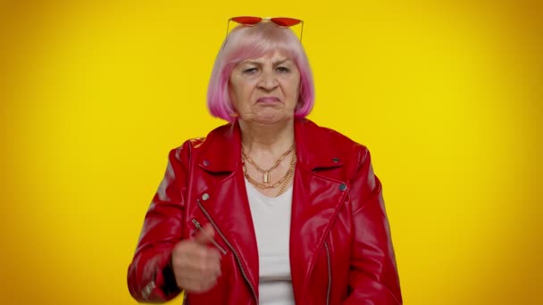 Расстроенная пожилая женщина показывает большие пальцы вниз знак жеста, выражая, неодобрение, недовольство, неприязнь — стоковое видео