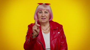 Gözlerine ve kamerasına bakan yaşlı bir kadın, seni birini gözetlerken, el kol hareketi yaparken izlediğimi göster.