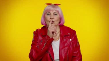 Yaşlı büyükanne, işaret parmağını dudaklarına bastırıyor. Sessiz jest işareti yapıyor. Sırları açıklamıyor.