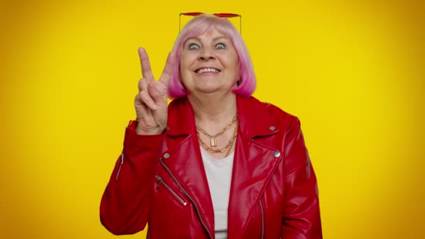 Volwassen grootmoeder met overwinningsteken, hopen op succes en winnen, doen vredesgebaar, glimlachen — Stockvideo