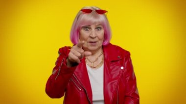 Yaşlı, beyaz saçlı kadın kameraya bakıyor. Telefon hareketleriyle beni geri ara diyor.