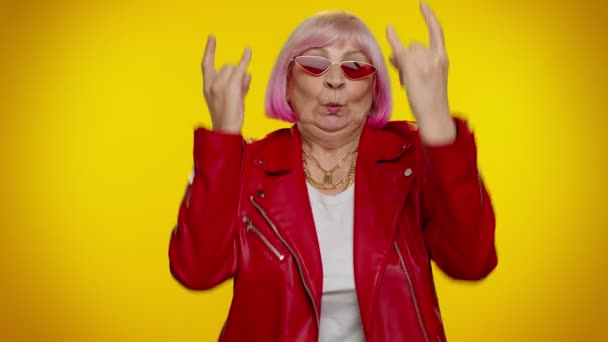 Deliziata deliziata donna anziana pazza mostrando il gesto rock n roll per mano, segno fresco, ballare — Video Stock